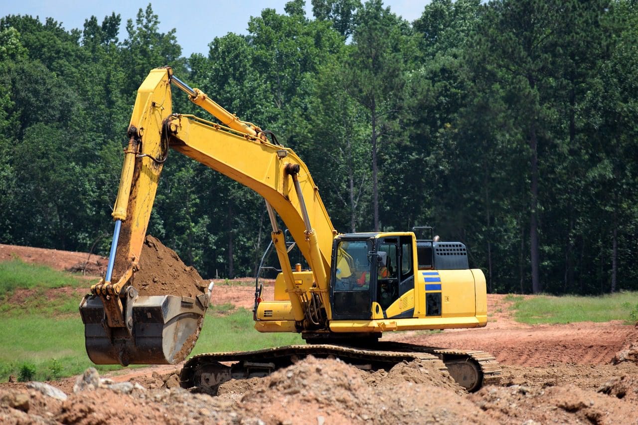 A yellow and black excavator is on the ground