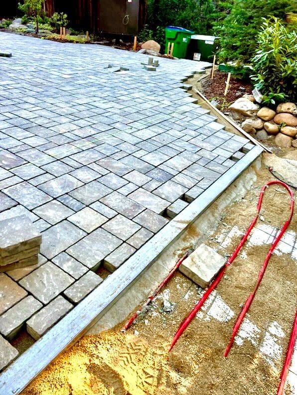 A brick walkway being laid with stone and concrete.